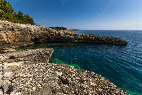 Tableau sur toile The rocky coast of Cyclone Beach near Pula in Croatia with its crystal-clear Adr