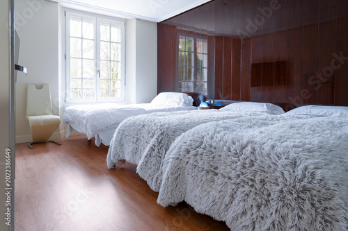 Budget hotel room interior with three beds arranged in compact shared accommodation layout. 