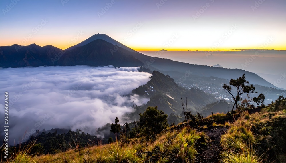 Obraz premium Mountain peaks rise above a sea of clouds at sunrise, panoramic view