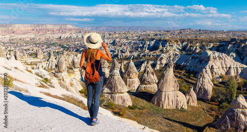 Foto Young woman traveler with backpack and straw hat looking at Cappadocia fairy chi