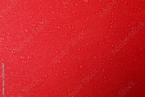 Top view photo of water drops on red background