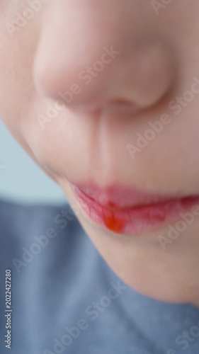 Close shot of a child tasting a sweet summer berry. Natural flavors stimulate taste buds and encourage healthy eating habits from a young age. 