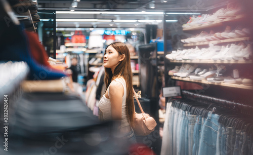 Fotografía Young adult woman youth culture gen Z shopping choosing used clothing second han