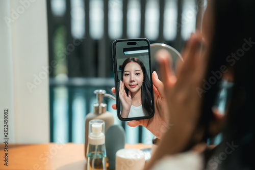 Quadro su tela Modern woman uses an AI skin analysis app at home, scanning her skin for instant
