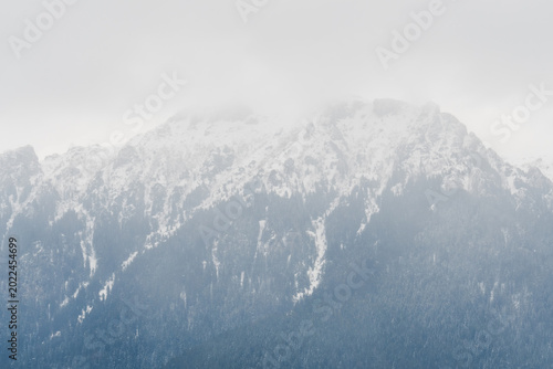 The Romanian Bucegi (Carpathian) Mountains Covered by Snow and Mist on a Rainy Late Spring Afternoon