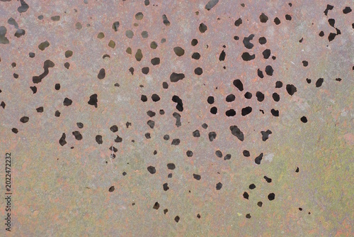 brown metal texture of rusty iron wall with a row of round holes