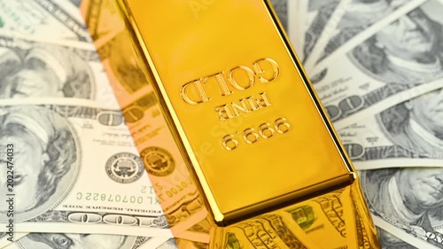 gold bars with dollar bills
