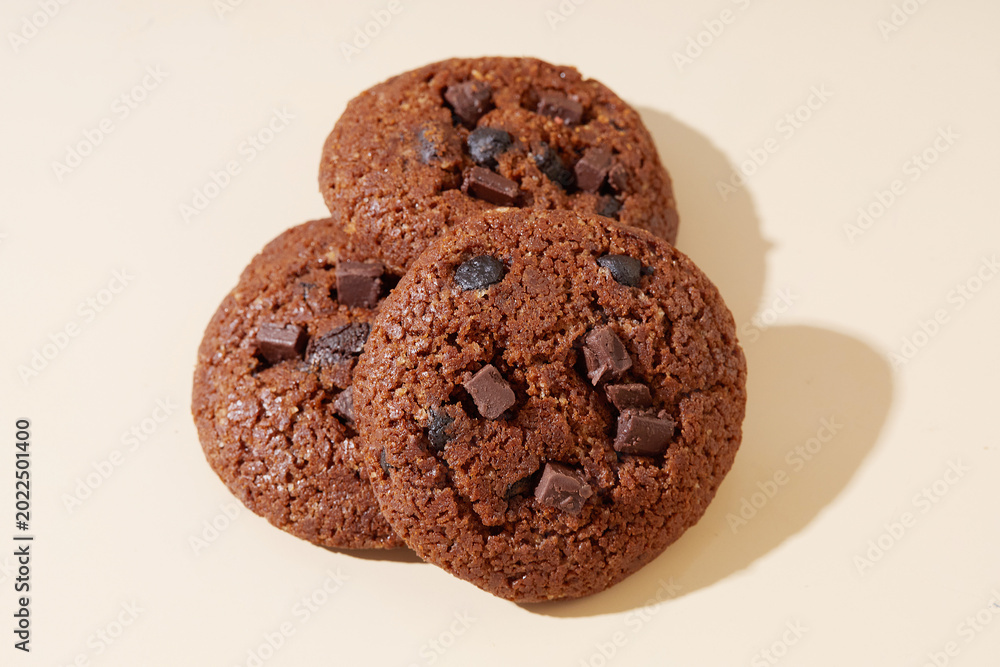 Fototapeta premium Delicious Chocolate Cookies Stacked on a Simple neutral Background for Appealing Dessert Packaging Design