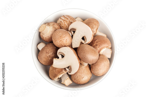 Brown champignon mushroom a ceramic bowl isolated on white background. Top view. Flat lay