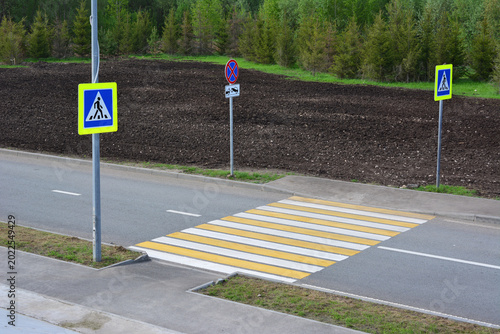 Pedestrian crossing on an asphalt road with road signs high angle view