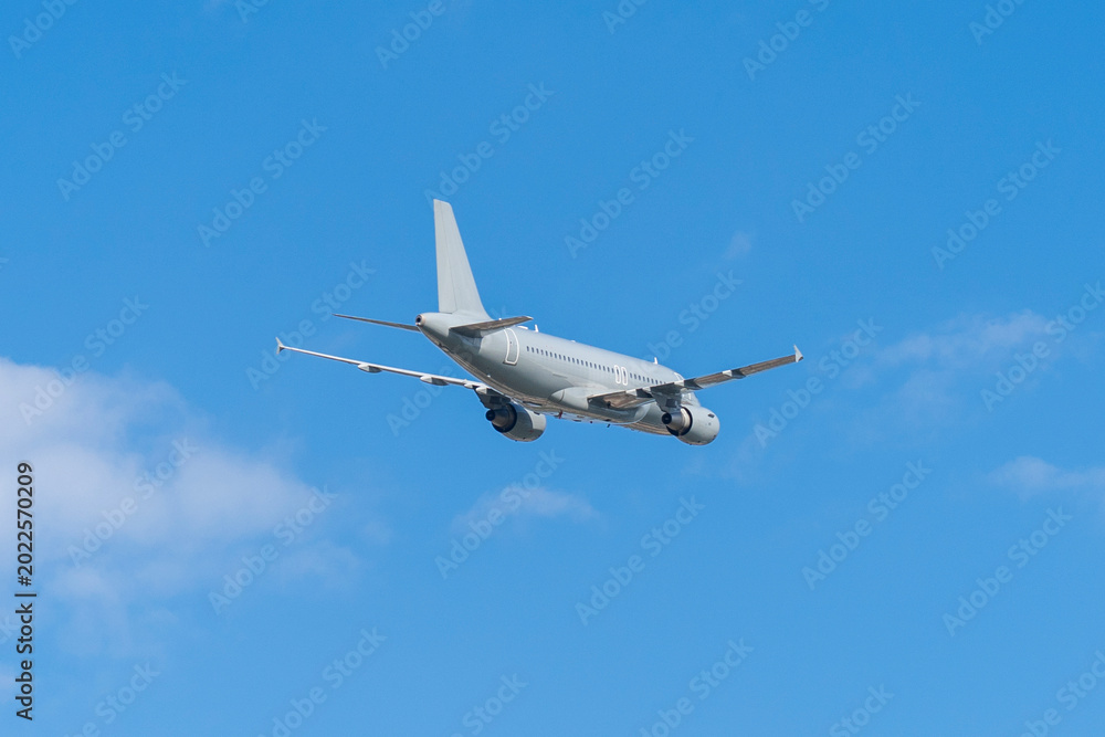Fototapeta premium Gray hungarian military transport plane flying in the blue sky