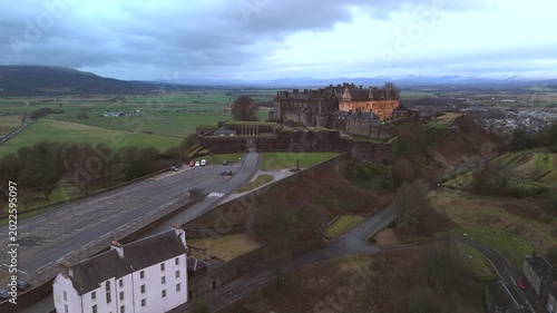 Stirling Scotland city skyline drone flyover and mountains in the distance. Clouds cover the sky, creating an atmosphere in the Scottish highlands