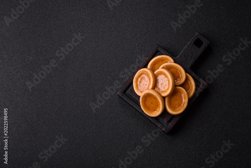 Fotografie Round mini tartlets with citrus or peach jam and crumbly pastry