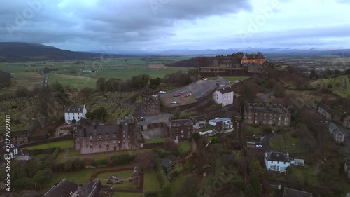 Stirling Scotland city skyline drone flyover and mountains in the distance. Clouds cover the sky, creating an atmosphere in the Scottish highlands