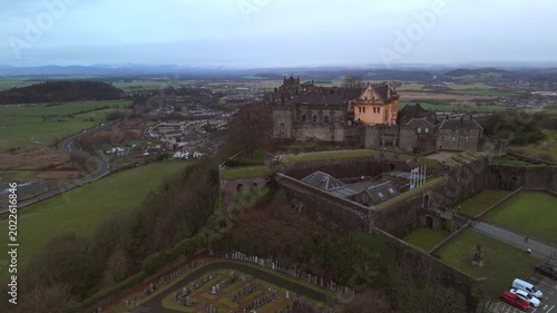 Stirling Scotland city skyline drone flyover and mountains in the distance. Clouds cover the sky, creating an atmosphere in the Scottish highlands