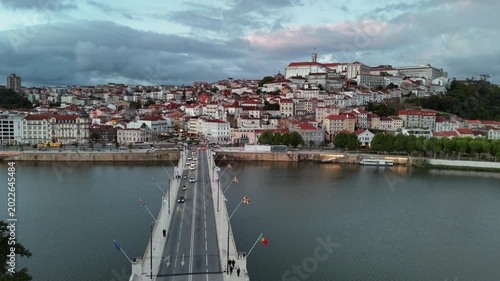 Aerial View of Bridge Over River Leading to Historic Hillside City With Red Rooftops at Twilight