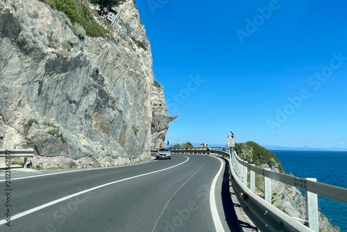 Breathtaking coastal road at Capo Noli in Liguria, Italy, winding along dramatic cliffs above the Mediterranean Sea.