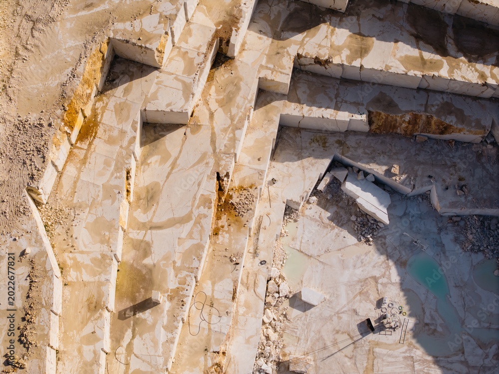 Fototapeta premium Marble quarry terraces excavated and filled with pools aerial view