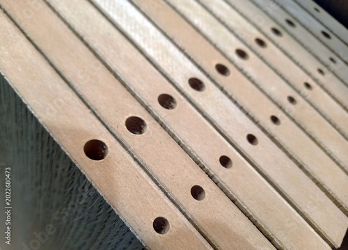 holes on furniture parts for assembly and installation of fasteners in production. close-up. oak veneer-covered