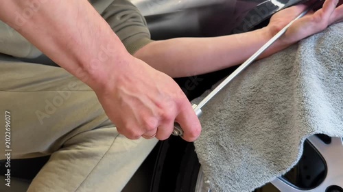 PDR. Process of paintless dent repair on car body. The mechanic at the auto shop with tools to repair dents in car body. Body repair. A specialist repairs a dent on the car body without painting. PDR.