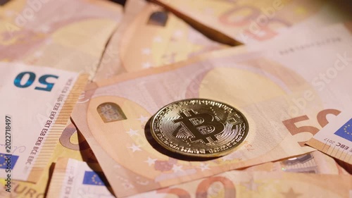 Bitcoin coin spinning on a group of euro banknotes
