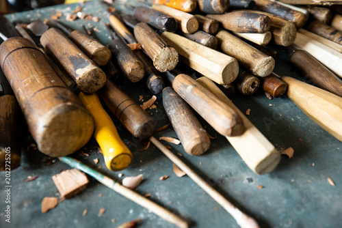 Professional wood carving tools gouges and wooden mallet on an artisan workbench