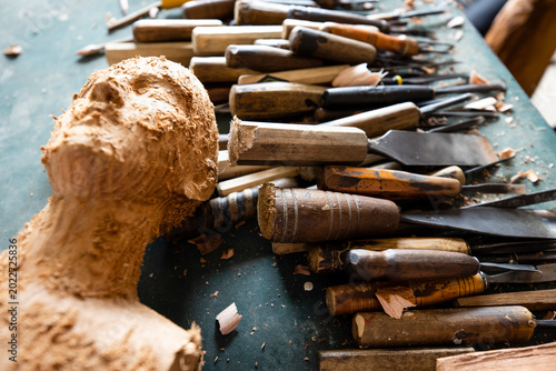Fotografie Professional wood carving tools gouges and wooden mallet on an artisan workbench