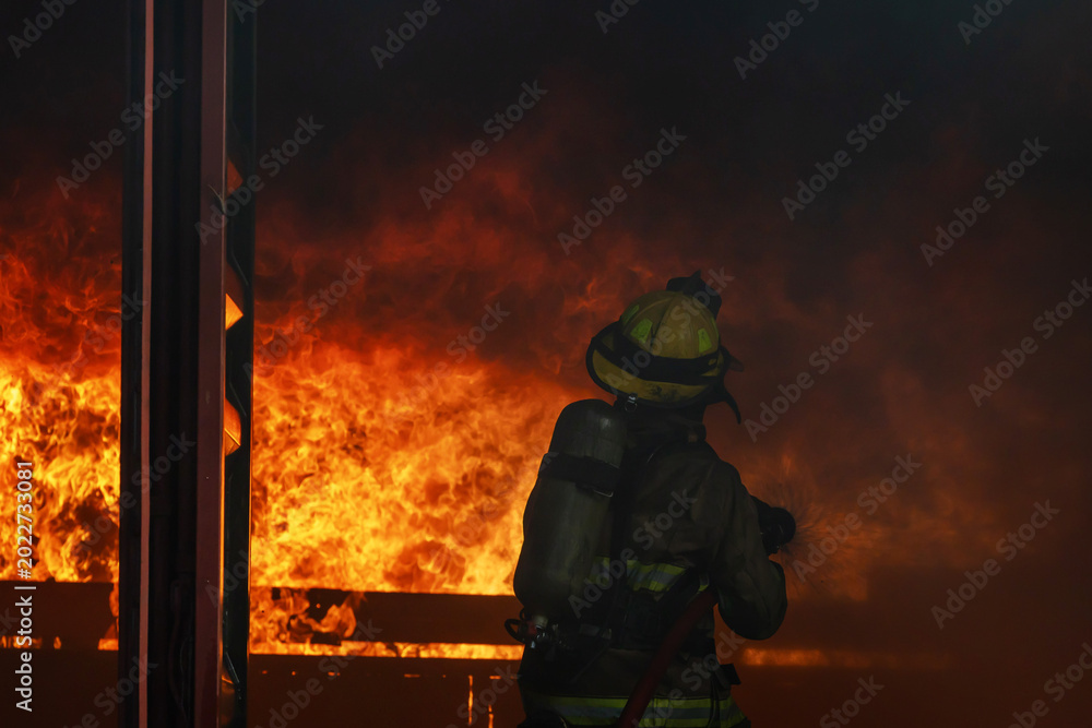 Naklejka premium Firefighter try extinguish the blaze fire flame