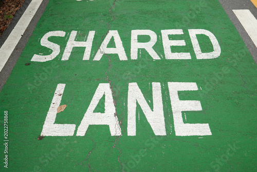 Photos Shared Lane Text Painted on Green Asphalt Surface