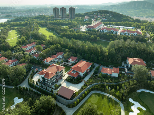Foto Aerial view of red-roofed villas adjacent to a lush golf course with surrounding