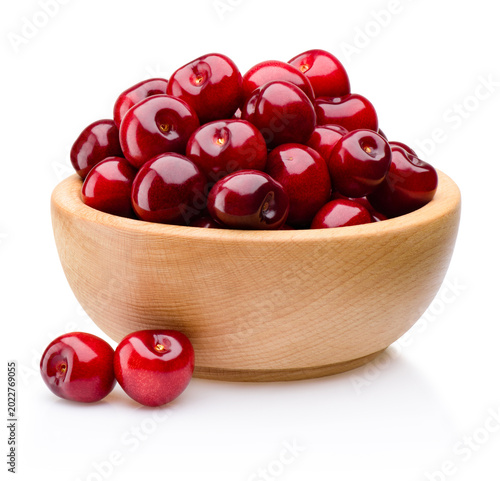 Fresh red ripe cherries on wooden bowl isolated on white background