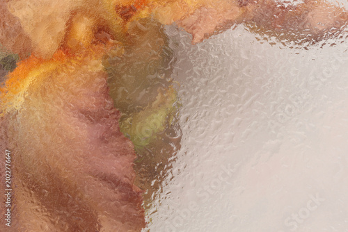 Smoke soft focus cream beige brown iris Flower through corrugated glass with wet flow water Drops. Abstract natural blur background.