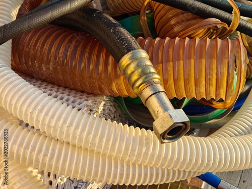 Fotografija Close-up of a metallic coupling of a discarded high-pressure hose lying on worn-out food-grade hoses