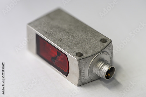 Photos Close-up of a rectangular optical sensor with a metallic housing.