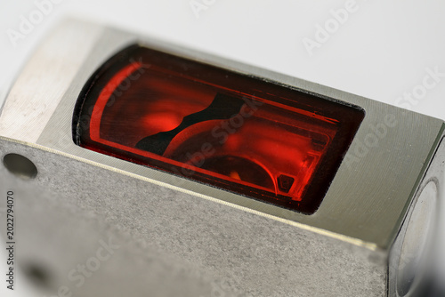 Foto Close-up of a rectangular optical sensor with a metallic housing.