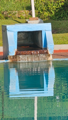 Billede på lærred The refection of clean water flows into the pool at a blue swimming pool