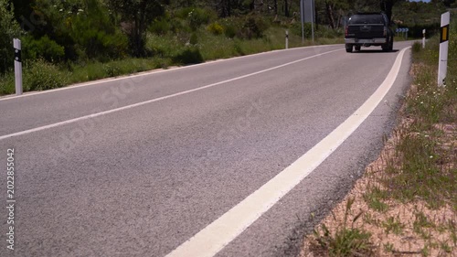 Detalle de una carretera comarcal de doble sentido y arcenes estrechos. Madrid, España, mayo de 2026.