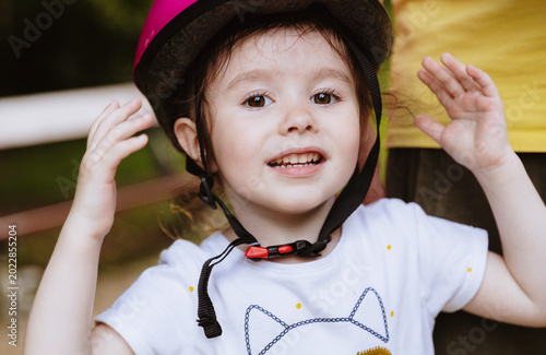 Obraz na plátne Beautiful brown-eyed girl in a helmet in the park.