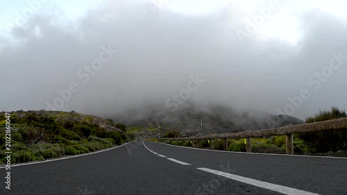 Car approaching through Teide National Park road with fast cloud inversion