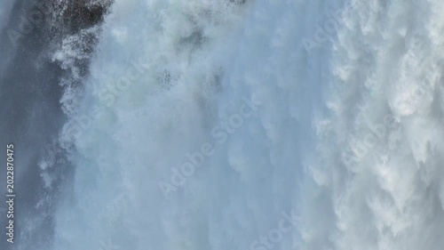 Waterfall crashing down with intense power creating heavy mist and white foam in a natural setting in 120fps 4K Slow Motion