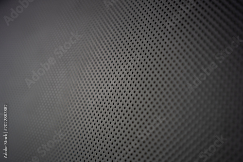 Foto Close up of black perforated leather texture used in luxury car interiors for seat upholstery and ventilation, showcasing a uniform pattern of small holes on a dark surface