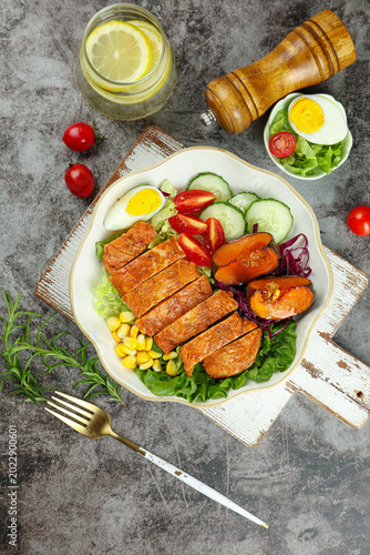Photos Healthy Grilled Chicken Salad with Fresh Vegetables and Boiled Egg on Rustic Woo
