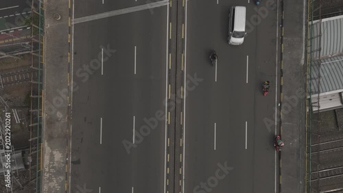 Top down aerial view of city highway traffic with cars and motorcycles driving on asphalt overpass bridge road