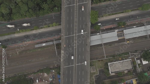 Aerial top down view of a train station and flyover bridge with traffic in Jakarta