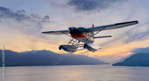 Fotografie Seaplane Floatplane Flying Over Coastal Mountains At Sunset Near BC, Canada With