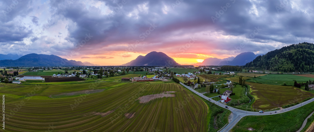 Fototapeta premium Sunset Over Farmland and Mountains in Fraser Valley British Columbia Canada Rural Panorama