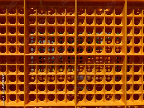 closed-up full frame shot of orange plastic crate commonly used for carrying fruits and vegetables to fresh markets.