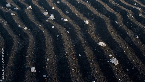 White salt crystals covering dark volcanic sand dunes