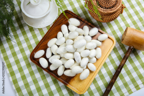 Bild auf Leinwand White Silkworm Cocoons on Wooden Tray for Silk Textile Production