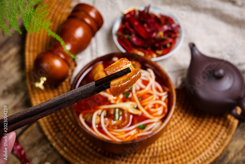 Fotografie Spicy noodle soup with braised pork and chopsticks